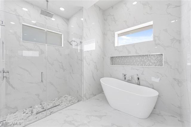 full bathroom with stone wall, a freestanding tub, visible vents, marble finish floor, and a marble finish shower