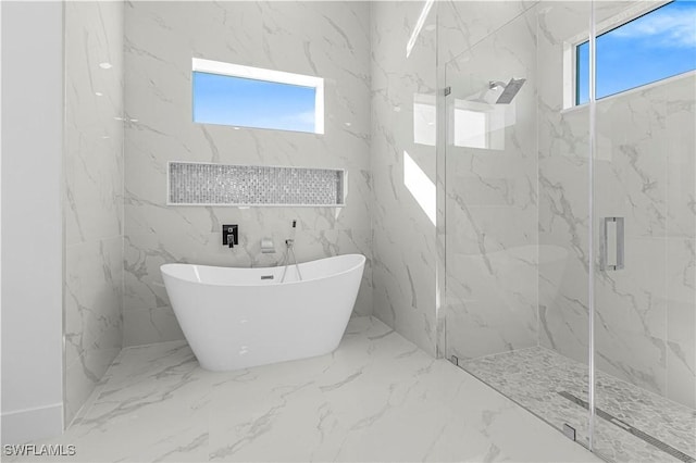 bathroom with a freestanding tub, a healthy amount of sunlight, marble finish floor, and a marble finish shower