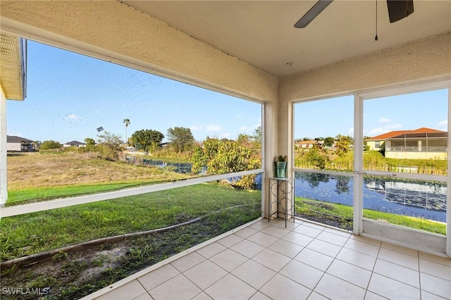 unfurnished sunroom with a water view and ceiling fan