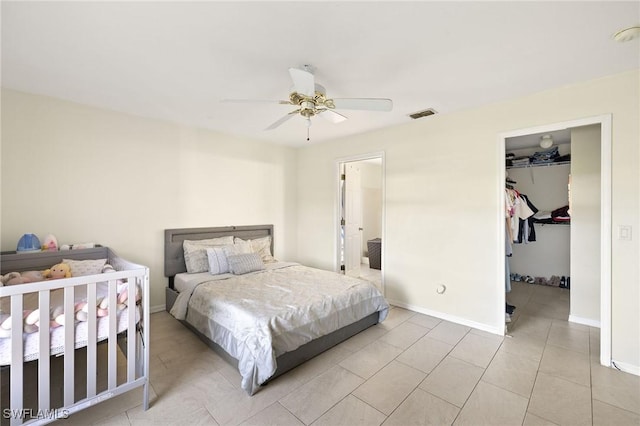 bedroom with baseboards, visible vents, a walk in closet, and a closet