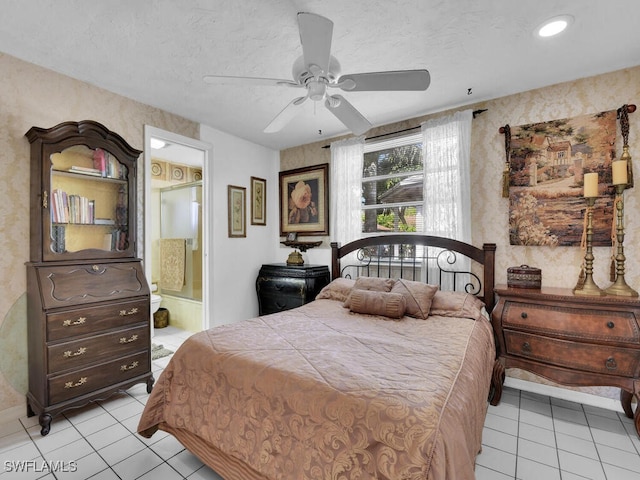 bedroom featuring a textured ceiling, ceiling fan, light tile patterned floors, connected bathroom, and wallpapered walls