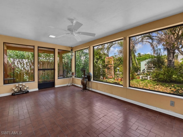 unfurnished sunroom with a healthy amount of sunlight and a ceiling fan