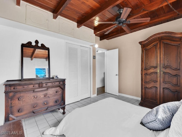 bedroom featuring light tile patterned floors, wood ceiling, ceiling fan, beamed ceiling, and a closet