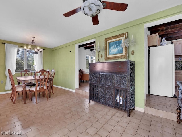 dining space featuring ceiling fan with notable chandelier, baseboards, and light tile patterned flooring