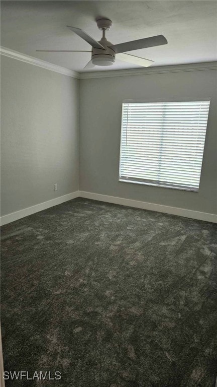 spare room with dark carpet, baseboards, crown molding, and a ceiling fan