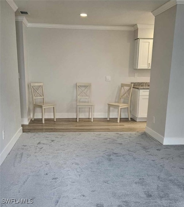 interior space featuring visible vents, baseboards, recessed lighting, ornamental molding, and light colored carpet