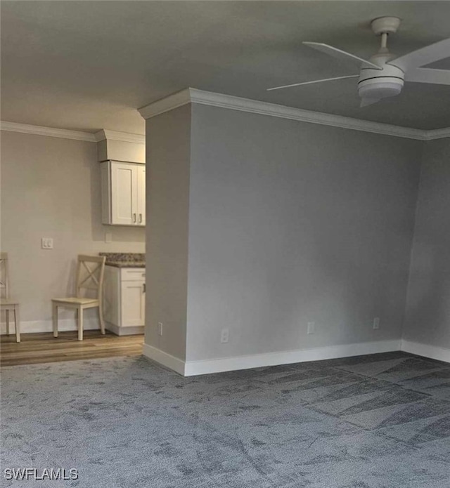 interior space featuring carpet flooring, baseboards, ceiling fan, and crown molding