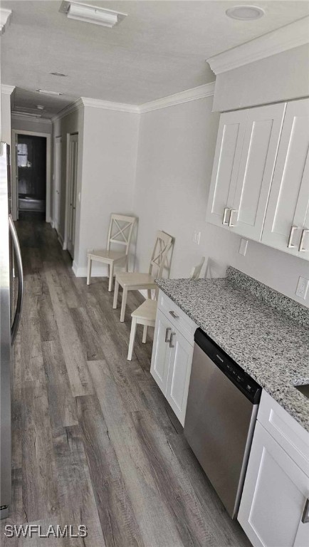 kitchen with stainless steel dishwasher, dark wood finished floors, crown molding, and freestanding refrigerator