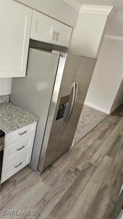 kitchen featuring white cabinetry, crown molding, wood finished floors, and light stone countertops