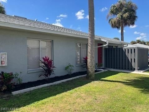 view of side of home featuring stucco siding and a lawn