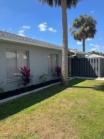 exterior space with a lawn and stucco siding