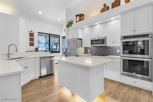 kitchen featuring a sink, tasteful backsplash, appliances with stainless steel finishes, and white cabinetry