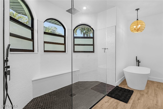 full bath with a wealth of natural light, a walk in shower, baseboards, and wood finished floors