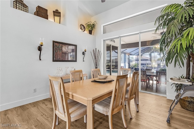 dining space with baseboards and light wood-type flooring