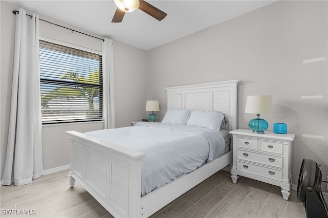 bedroom featuring light wood-style flooring, baseboards, and ceiling fan