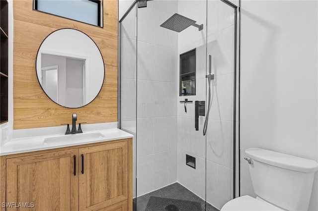 bathroom with a stall shower, toilet, and vanity