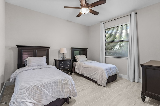 bedroom featuring a ceiling fan, light wood-type flooring, and baseboards