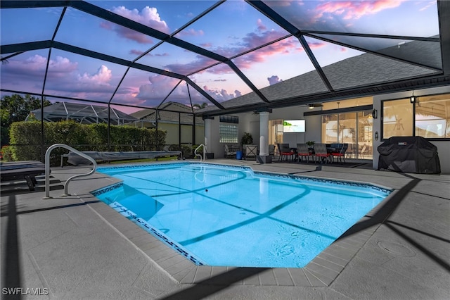 pool with grilling area, a patio, and glass enclosure