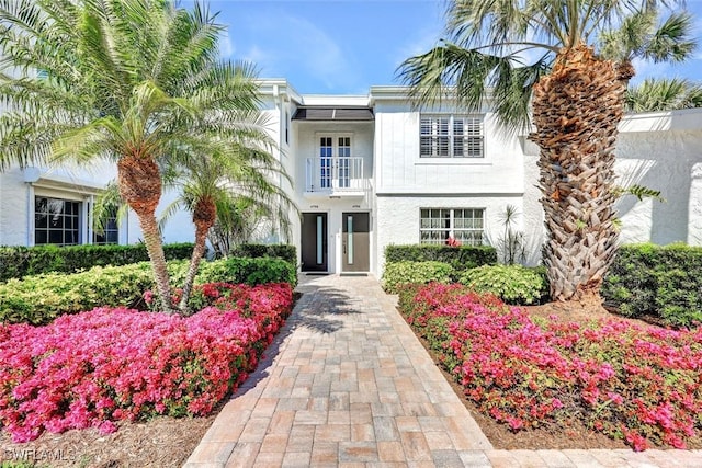 view of front of house with a balcony and stucco siding