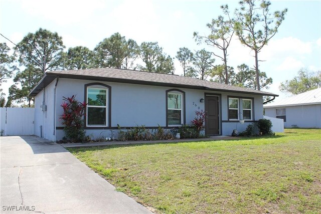 single story home with a front yard, concrete driveway, and stucco siding