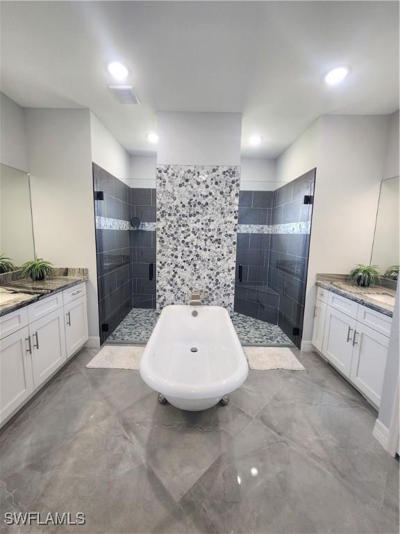 full bath with two vanities, a stall shower, marble finish floor, and a freestanding bath