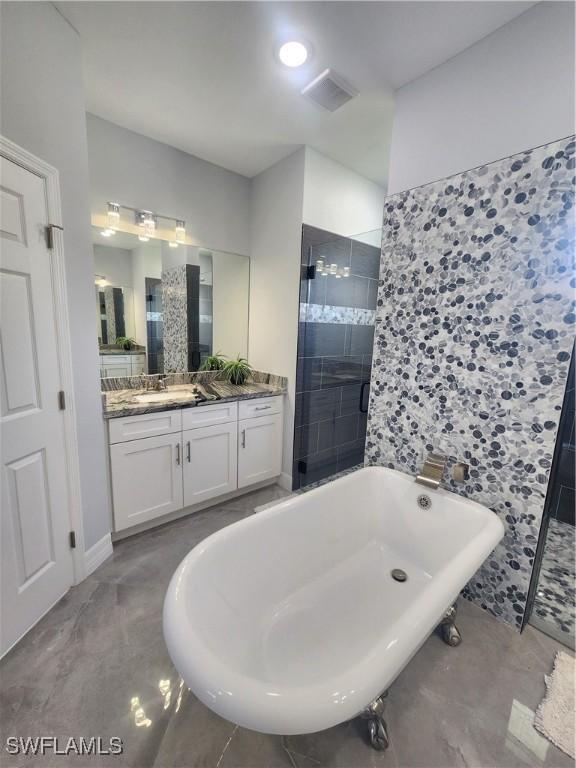 full bath featuring a freestanding tub, vanity, visible vents, and a shower stall