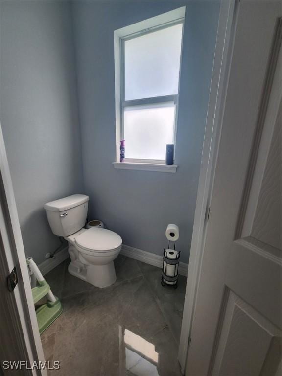 bathroom featuring toilet and baseboards