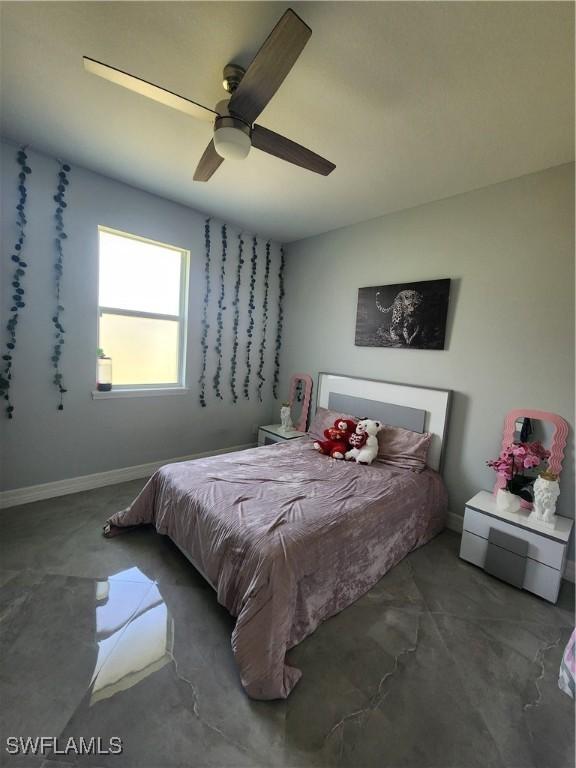 bedroom featuring baseboards, concrete floors, and ceiling fan