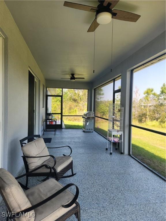 sunroom featuring a healthy amount of sunlight and a ceiling fan