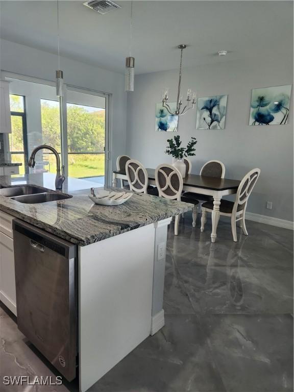 kitchen featuring a center island with sink, stone counters, a sink, white cabinets, and dishwasher