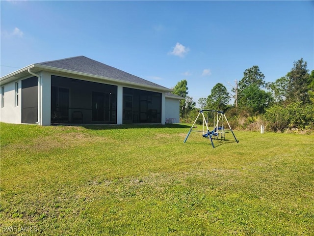 view of yard featuring a playground and a sunroom