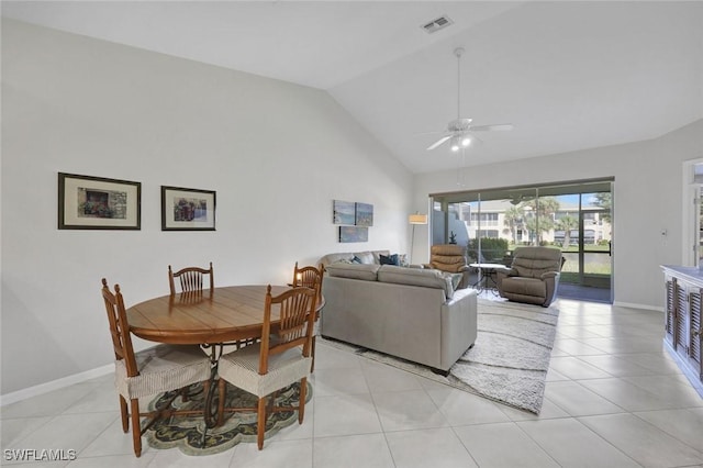 dining room with light tile patterned floors, visible vents, baseboards, ceiling fan, and high vaulted ceiling