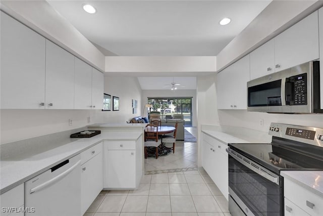 kitchen featuring a peninsula, white cabinetry, appliances with stainless steel finishes, and light countertops