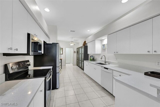 kitchen featuring recessed lighting, a sink, a ceiling fan, white cabinets, and appliances with stainless steel finishes