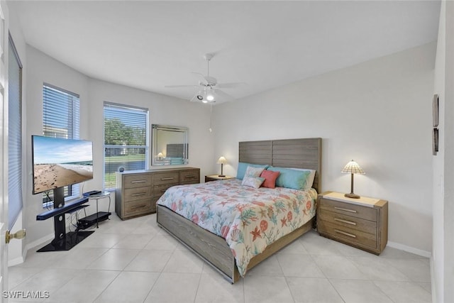 bedroom featuring light tile patterned flooring, ceiling fan, and baseboards