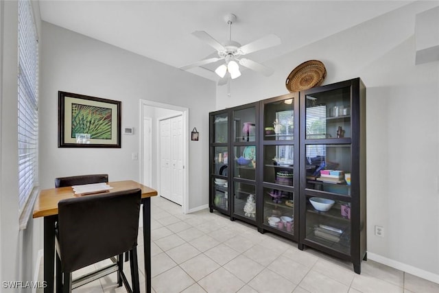 dining space featuring light tile patterned floors, baseboards, and a ceiling fan