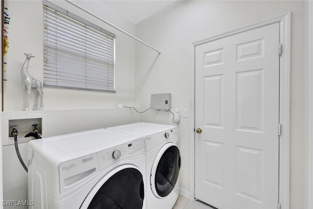 laundry room featuring laundry area, light tile patterned floors, and washer and clothes dryer