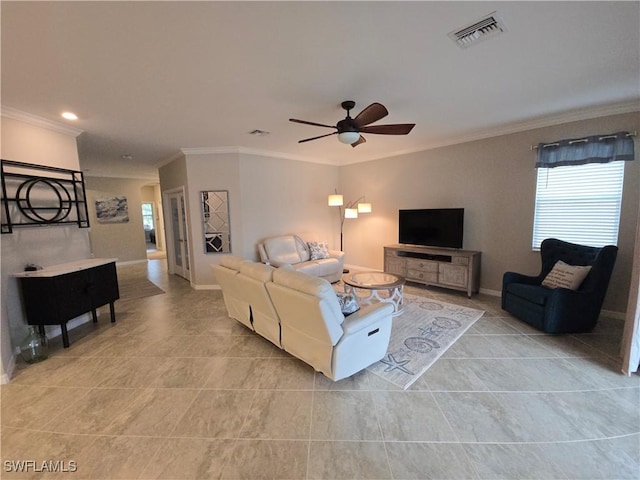 living room featuring light tile patterned floors, baseboards, visible vents, ceiling fan, and ornamental molding