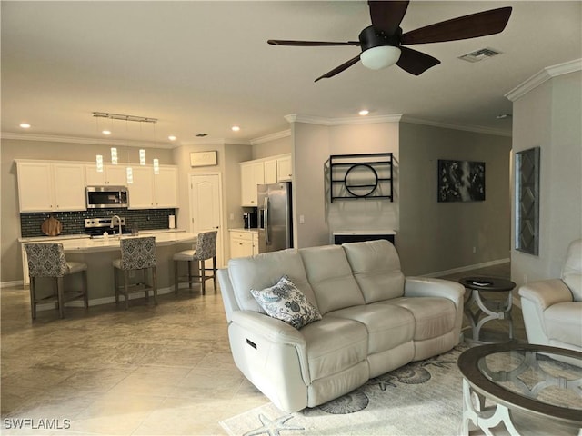 living room with visible vents, ceiling fan, baseboards, ornamental molding, and recessed lighting