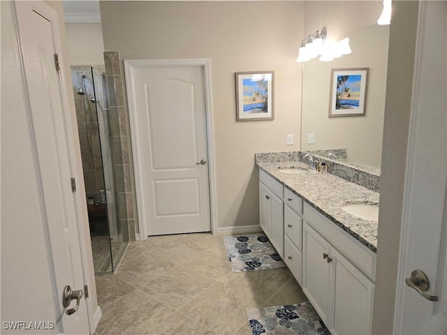 bathroom featuring double vanity, a stall shower, crown molding, and a sink