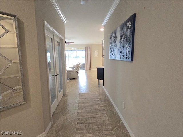 hall featuring tile patterned floors, french doors, baseboards, and crown molding