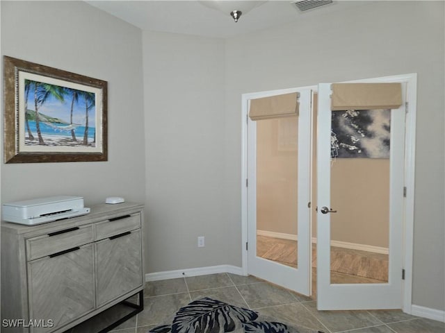 interior space with tile patterned flooring, french doors, visible vents, and baseboards