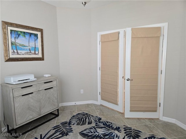 bedroom featuring baseboards and light tile patterned flooring