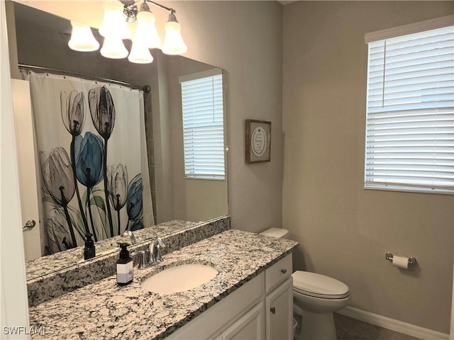 full bath featuring vanity, baseboards, toilet, a wealth of natural light, and a chandelier