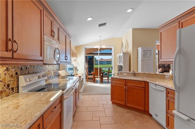 kitchen featuring tasteful backsplash, a notable chandelier, white appliances, and vaulted ceiling