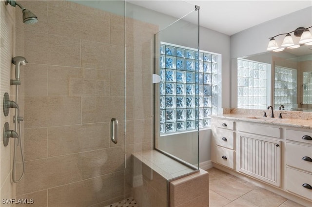 full bath with tile patterned flooring, a stall shower, and vanity