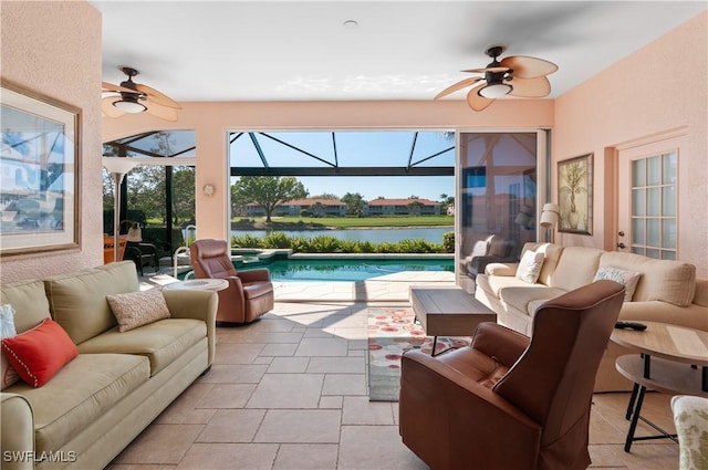 view of patio featuring glass enclosure, a ceiling fan, a water view, and outdoor lounge area