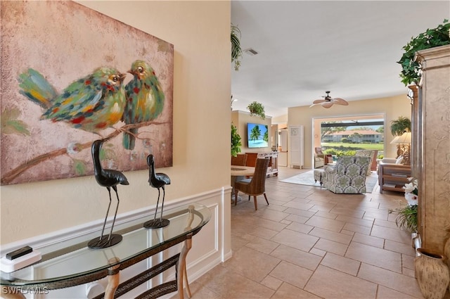 hall featuring visible vents and wainscoting