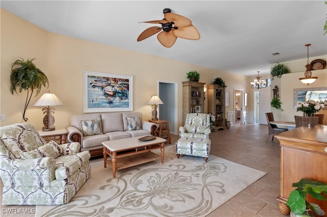 living area with visible vents, light tile patterned flooring, and ceiling fan with notable chandelier