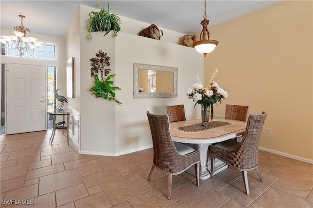 dining room featuring an inviting chandelier, stone finish flooring, and baseboards